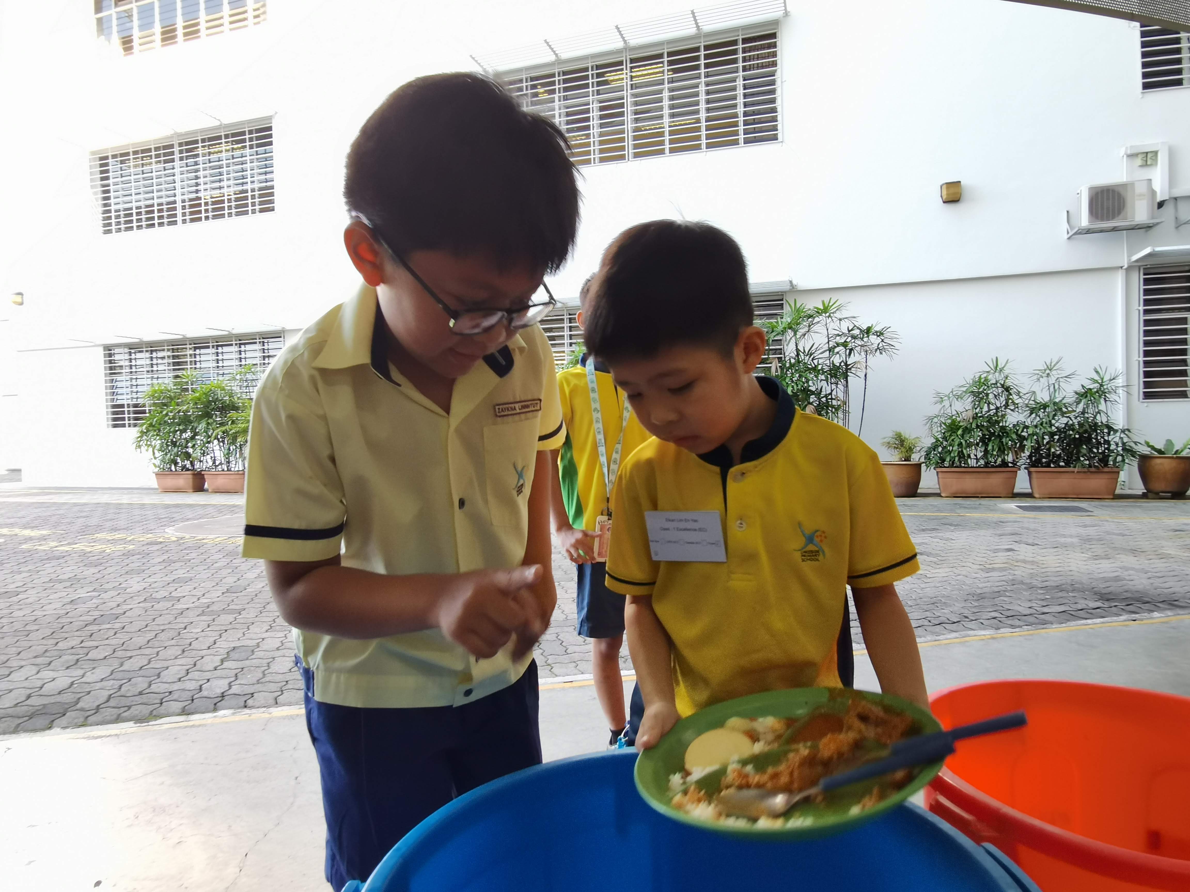 Our P4 buddies guiding the P1 students how to return their plates after eating during recess